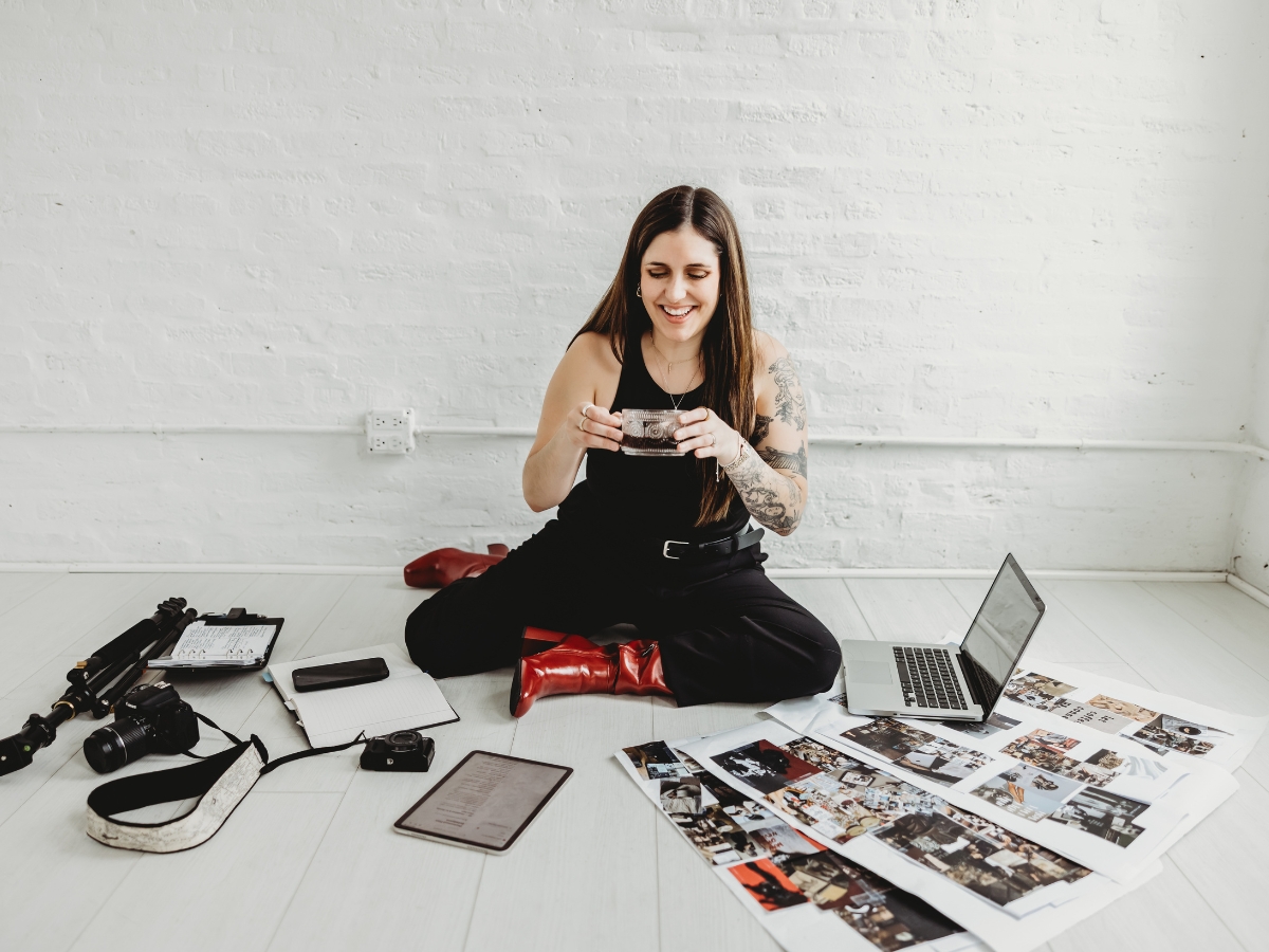 Social media manager conducting brand performance audit reviewing printed content and analytics